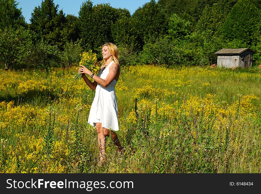 Blond woman in white dress on a meadow