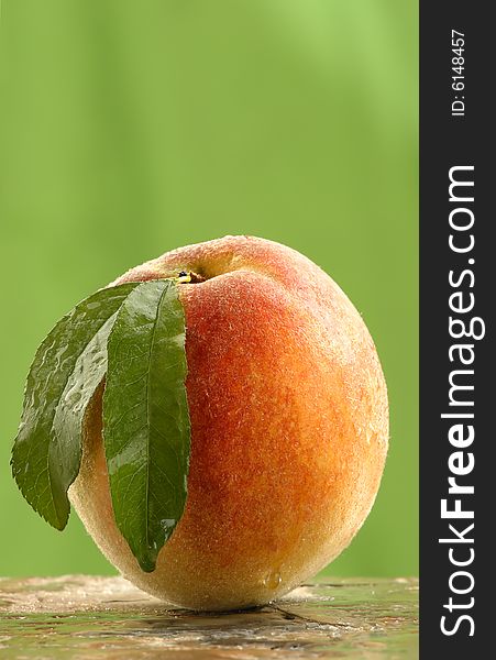 Whole fresh picked peach on a stone counter.