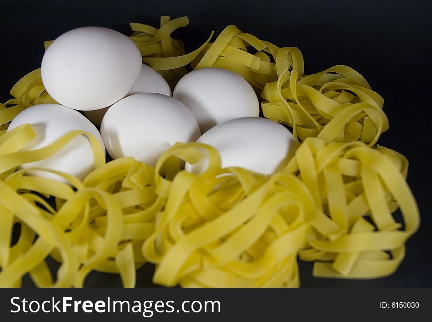 Six eggs over a nest of pasta. Six eggs over a nest of pasta