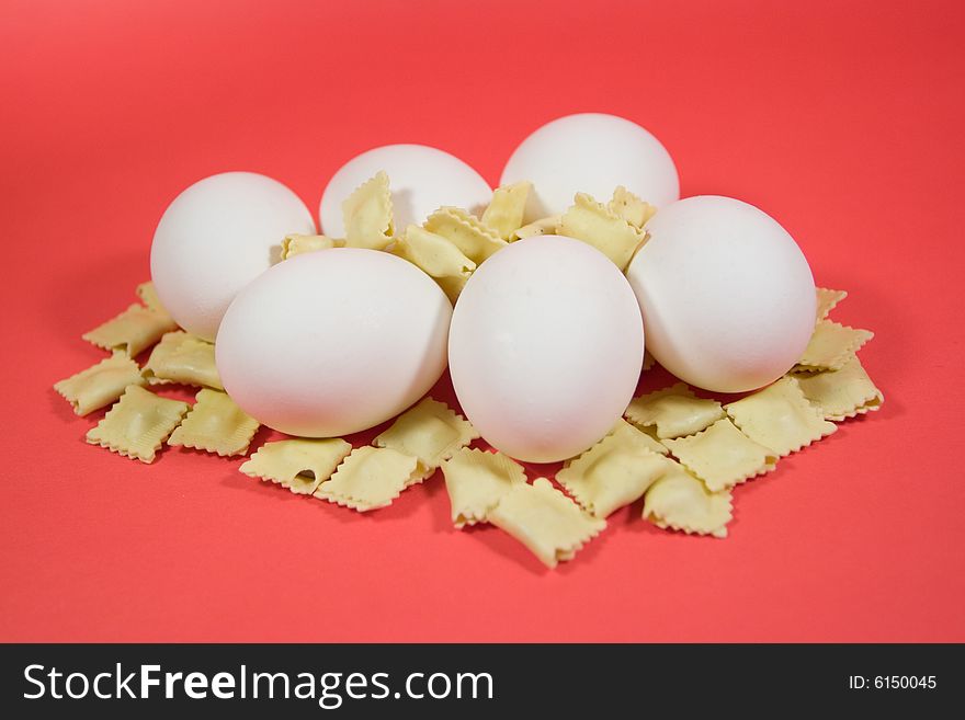 Eggs and pasta over red background