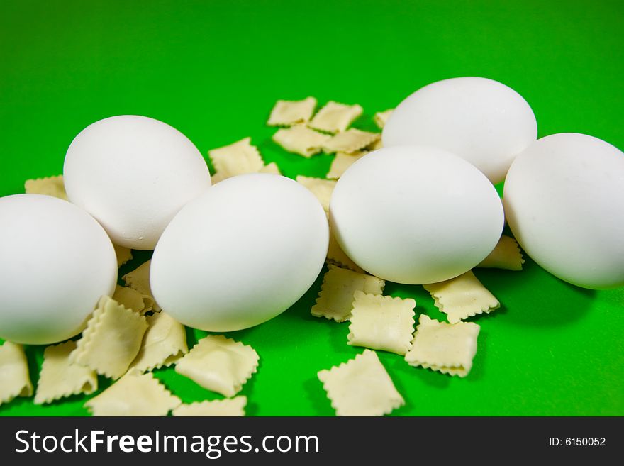Eggs and pasta over green background