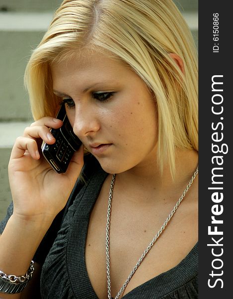 A young, blonde girl with a mobile phone.