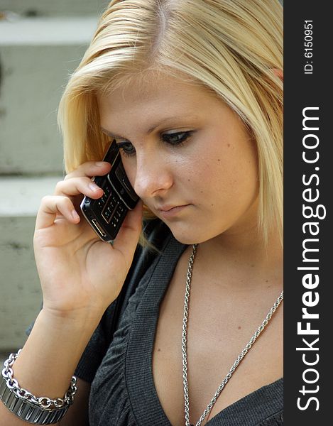 A young, blonde girl with a mobile phone.