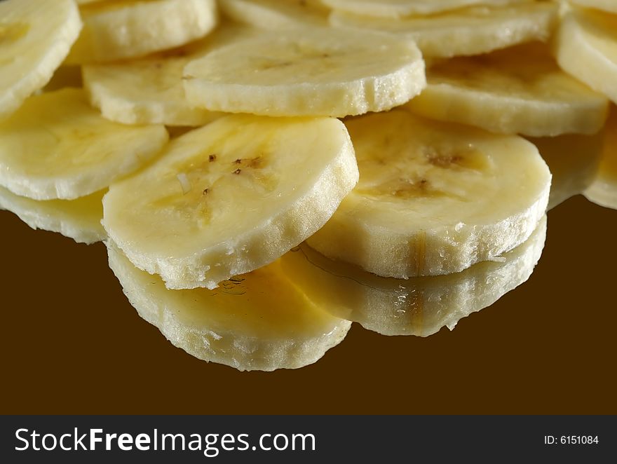 A close-up of sliced bananas, reflecting on brown.