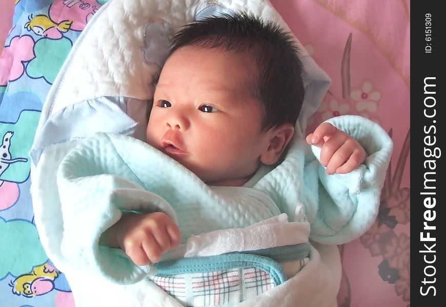 Lovely Baby in blue on a bed