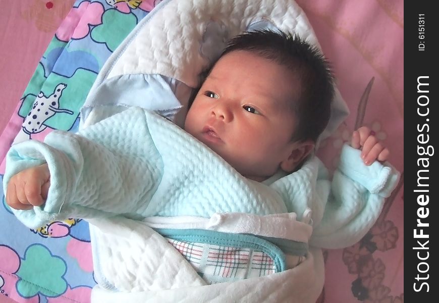 Lovely Baby in blue on a bed