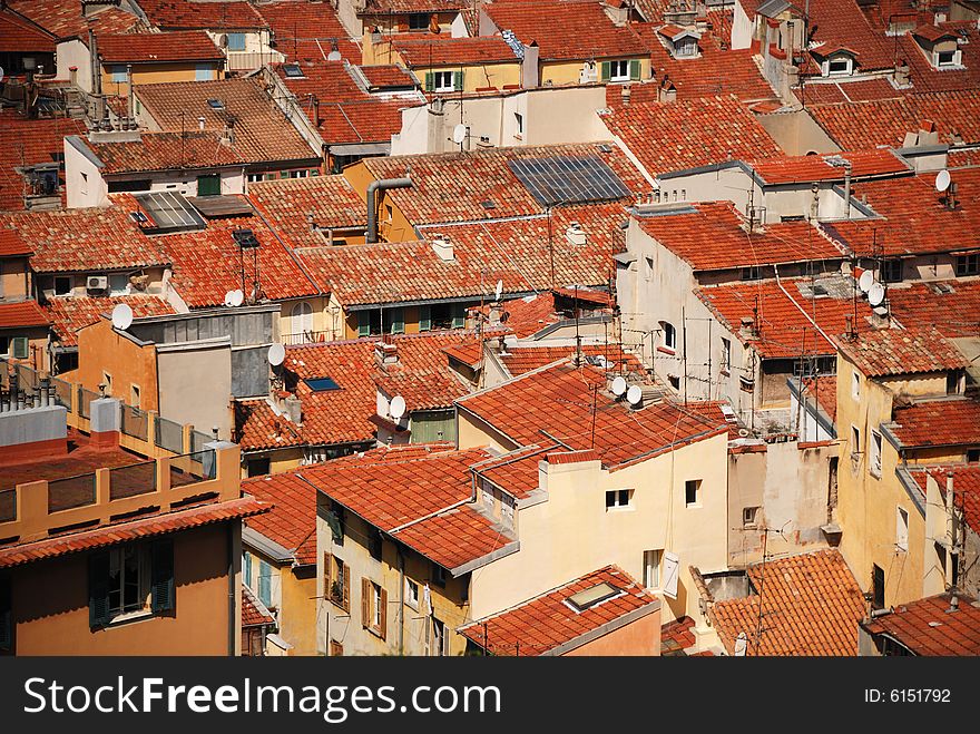 Equal red tile roofs in old residential district of Nice, dense building up, houses with white and yellow walls and open shutters,. Equal red tile roofs in old residential district of Nice, dense building up, houses with white and yellow walls and open shutters,