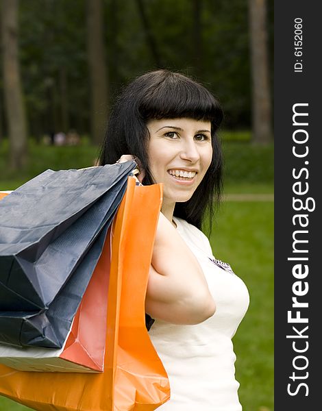 Attractive girl holding in hands bags with purchases