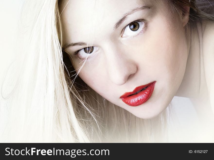 Woman with blond long hair and red lips; white background. Woman with blond long hair and red lips; white background