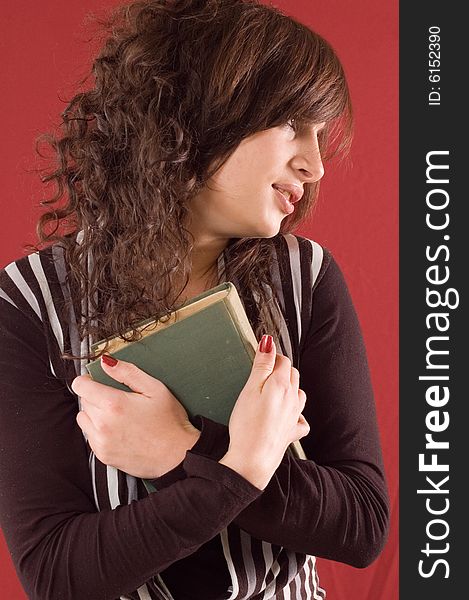 Young student girl with books on red backgrounds