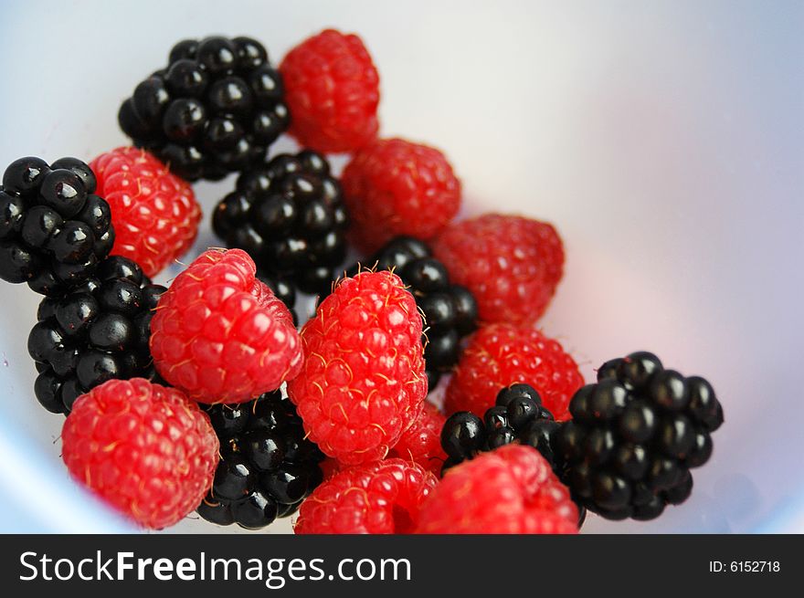 blackberry and raspberry in a blue bowl. blackberry and raspberry in a blue bowl