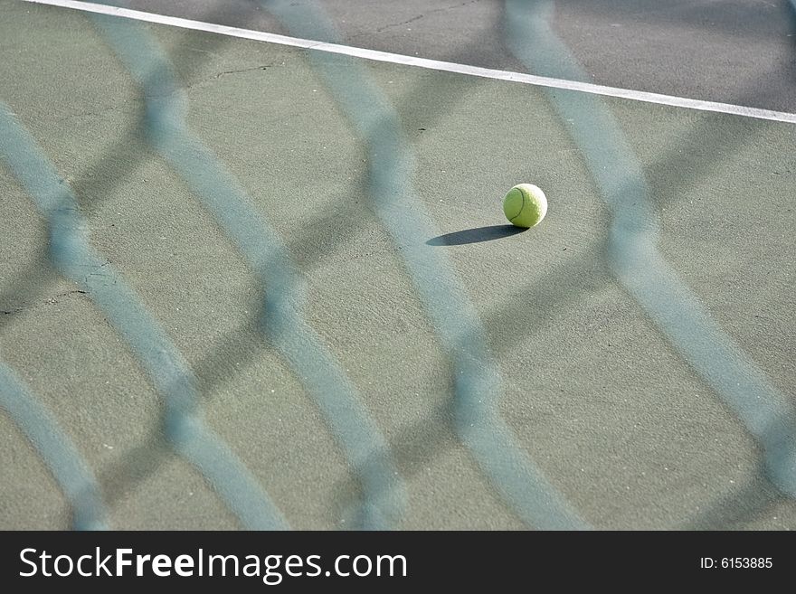 Single tennis ball left on the court - landscape exterior