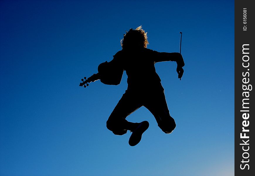 A person with a violin, jumping against the blue sky. A person with a violin, jumping against the blue sky.