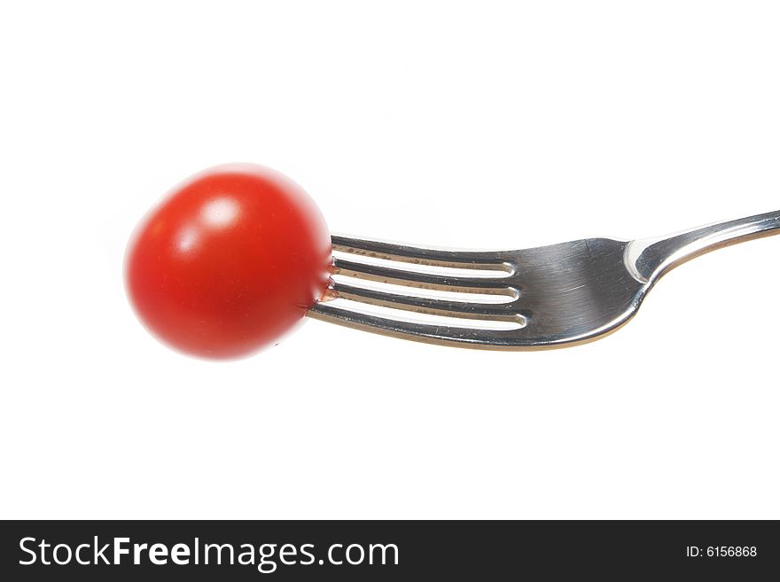 Red tomato on a fork isolated on white. Red tomato on a fork isolated on white