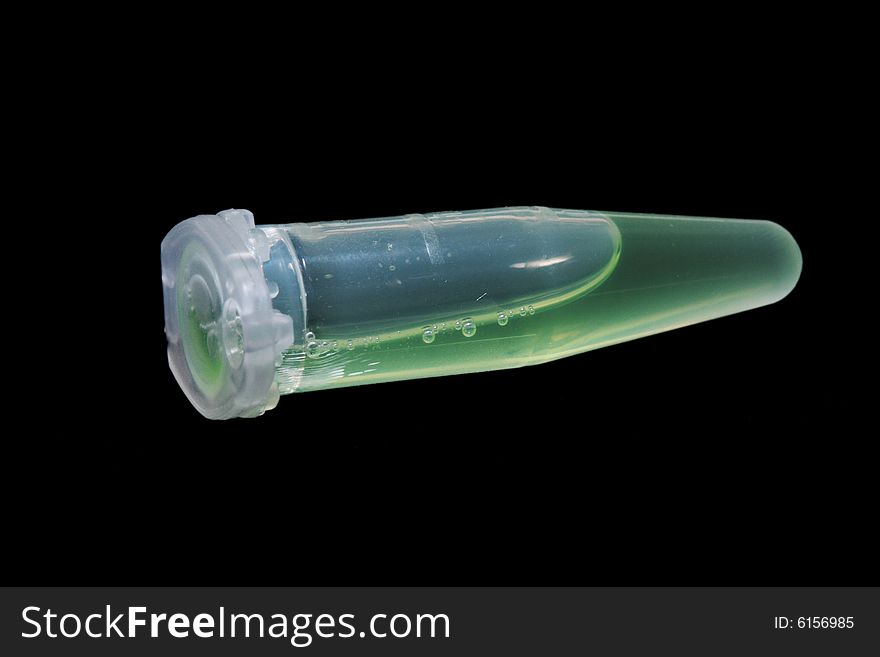 Eppendorf vial with green liquid isolated on black background