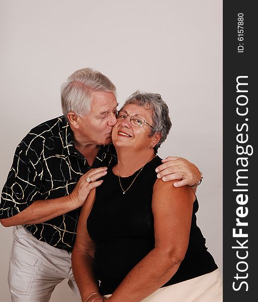 An happy senior couple kissing in front of the camera. An happy senior couple kissing in front of the camera.