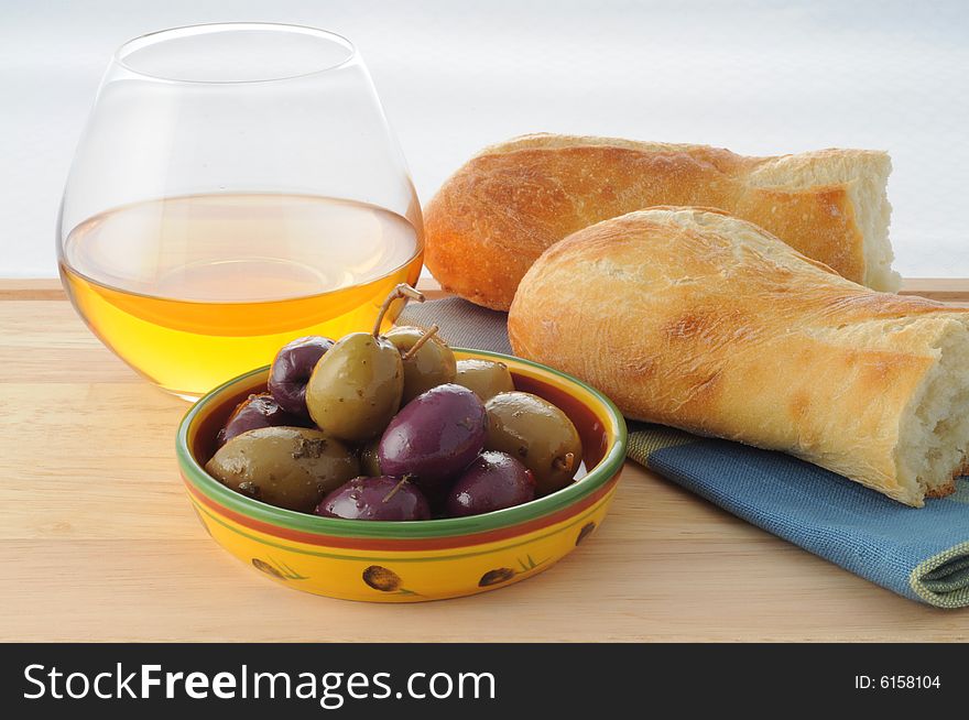 Bowl of spiced olives with bread and wine.