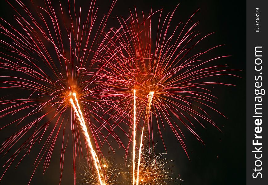 Large fireworks exploding high in the air in different colours
