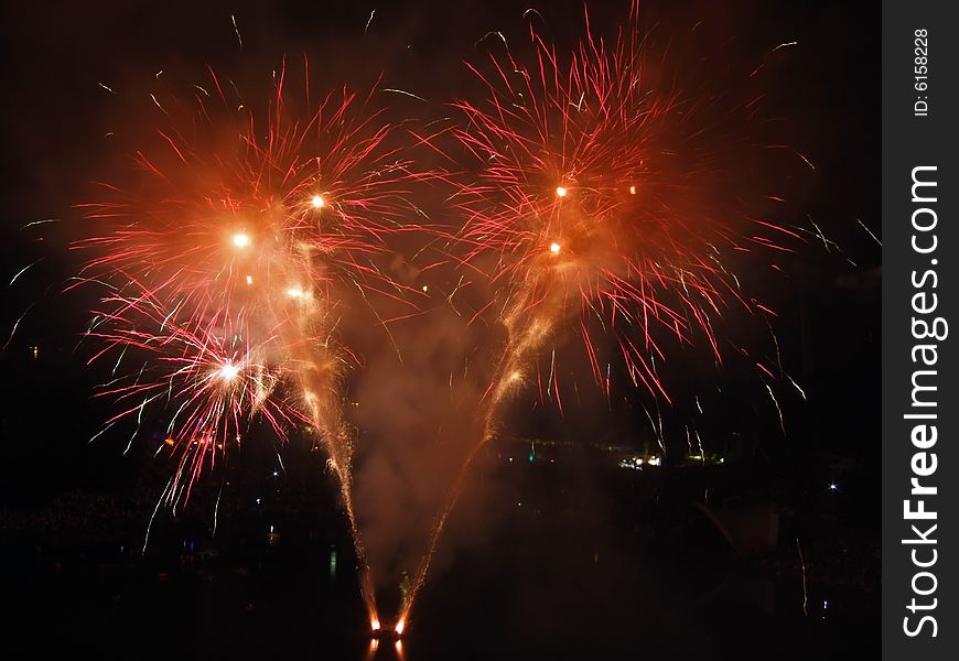 Large fireworks exploding high in the air in different colours
