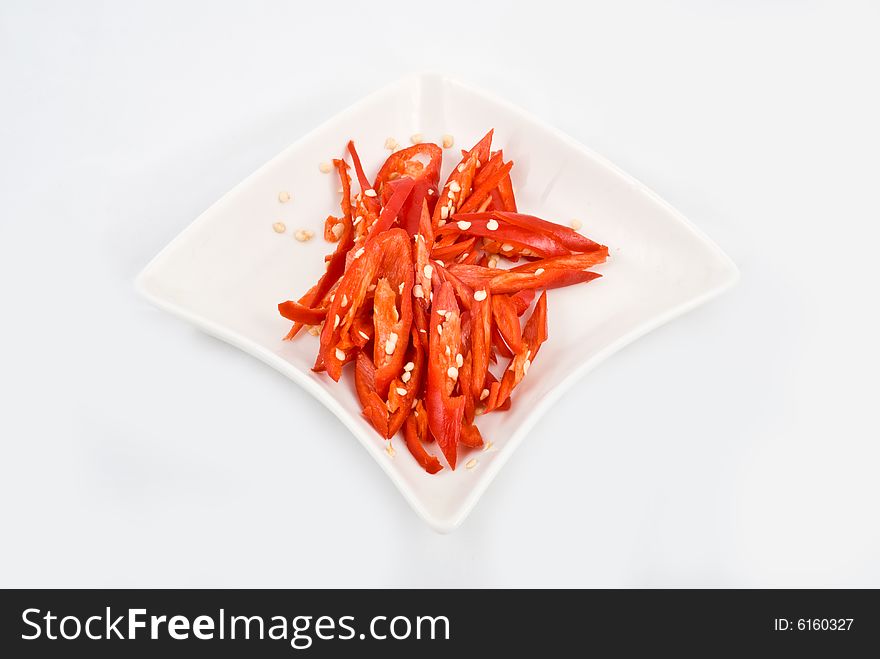 Fresh sliced chili in isolated white plate