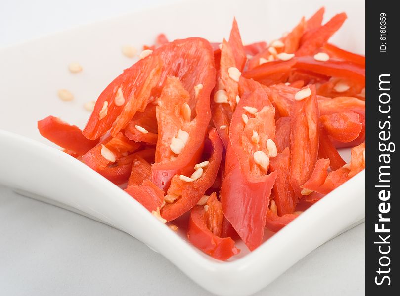 Fresh sliced chili in isolated white plate