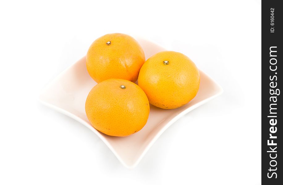 Oranges in white plate isolated on white background