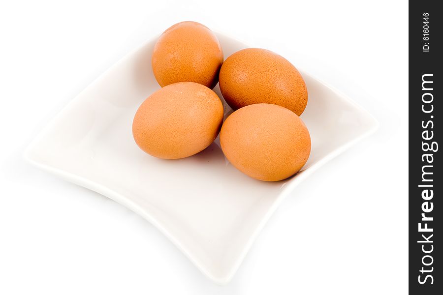 Brown eggs in white square plate isolated