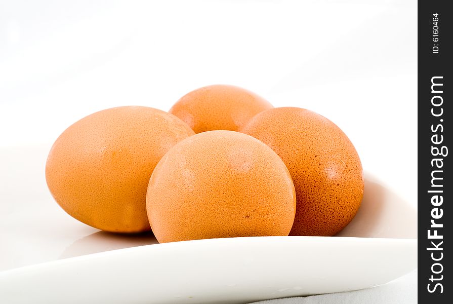 Brown eggs in white square plate isolated