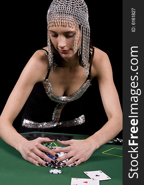 Attractive brunette woman colleting her winnings at the poker table. Attractive brunette woman colleting her winnings at the poker table