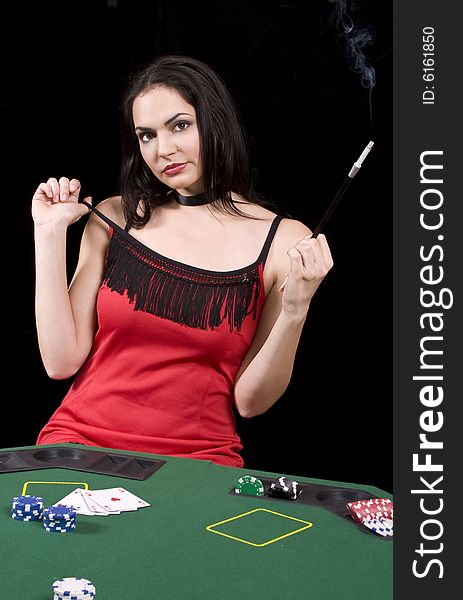 Attractive poker playing woman with and sigarette in extension looking at the camera. Attractive poker playing woman with and sigarette in extension looking at the camera
