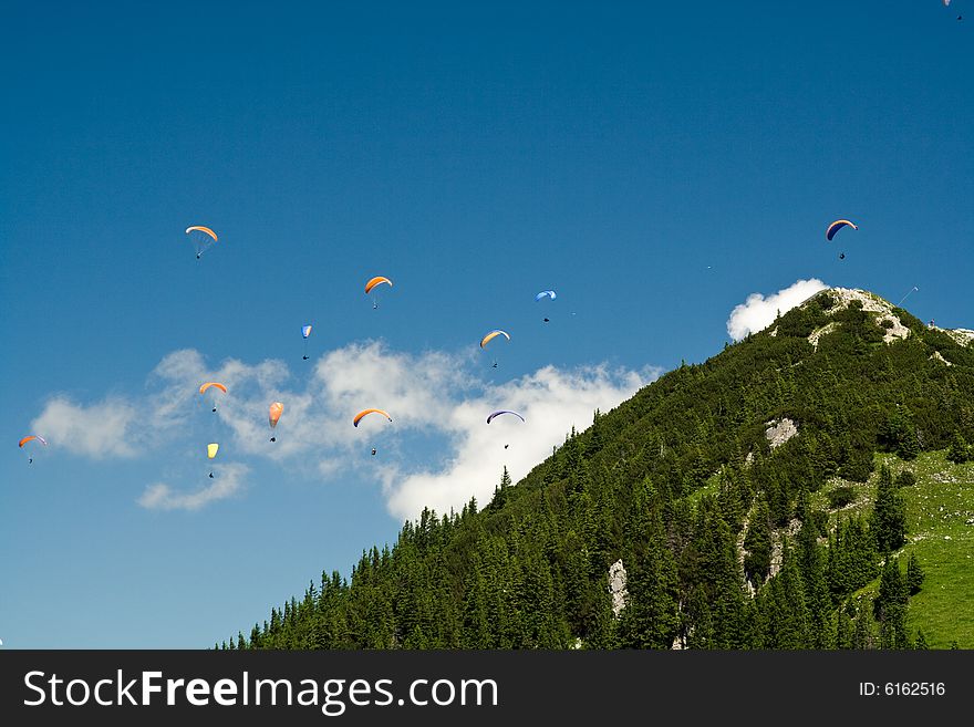 Plenty of paragliders are flying in the Alps, Bavaria, Germany. Plenty of paragliders are flying in the Alps, Bavaria, Germany