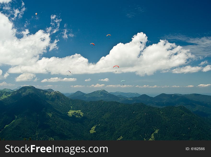 Plenty of paragliders are flying over the Alps, Bavaria, Germany. Plenty of paragliders are flying over the Alps, Bavaria, Germany