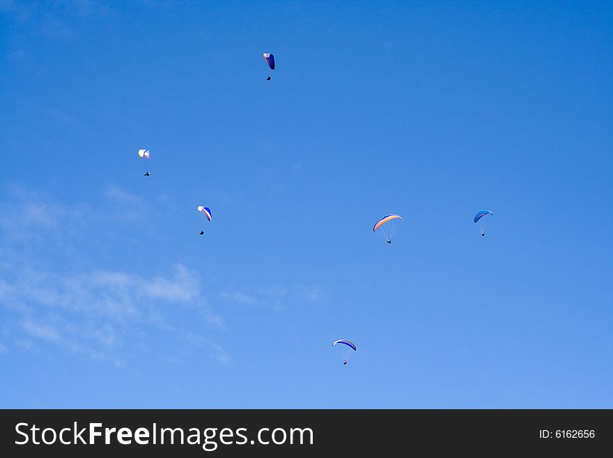 Plenty of paragliders are flying in the sky in the Alps, Bavaria, Germany. Plenty of paragliders are flying in the sky in the Alps, Bavaria, Germany