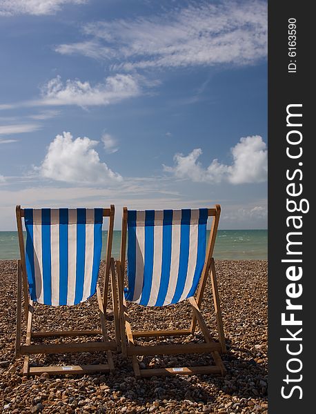 A couple of empty deck chairs facing a calm ocean. A couple of empty deck chairs facing a calm ocean