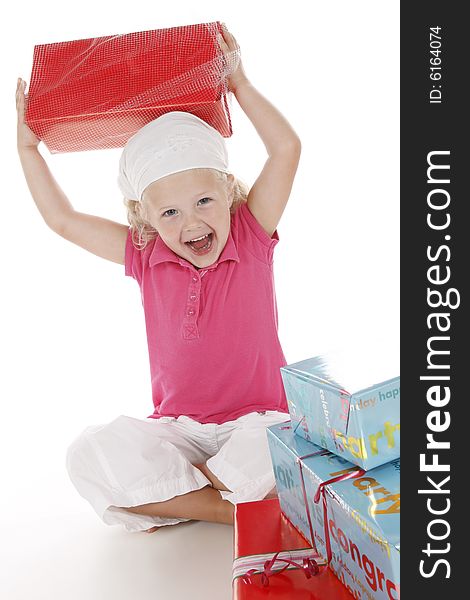 Cute little girl dressed in pink celebrating her birthday with several gifts. Cute little girl dressed in pink celebrating her birthday with several gifts