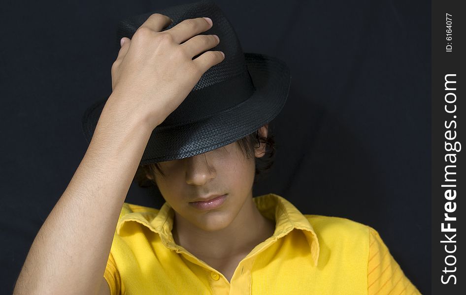 Teenager with black hat isolated on black background. Teenager with black hat isolated on black background