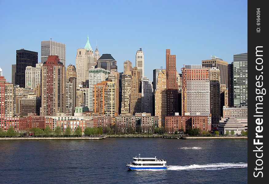 The evening view of a ferry-boat and skyscrapers of lower Manhattan, New York City. The evening view of a ferry-boat and skyscrapers of lower Manhattan, New York City.