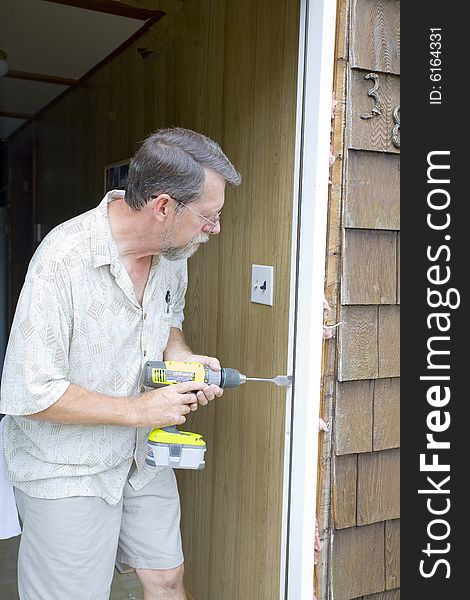 Elderly carpenter replacing exterior door frames, weather has promoted rot & chipping of the paint