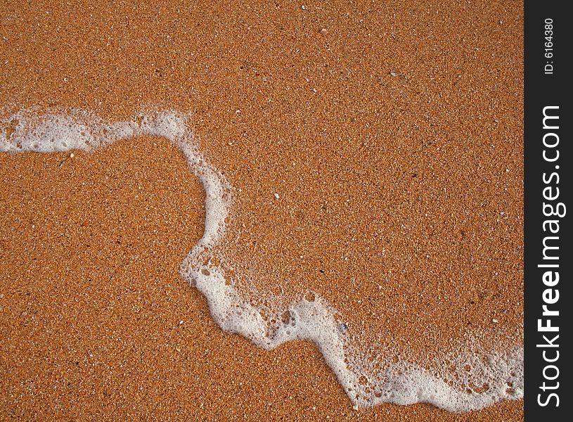 The sand of orange Raudisandur beach (Iceland) and foam left by the sea wave. The sand of orange Raudisandur beach (Iceland) and foam left by the sea wave.