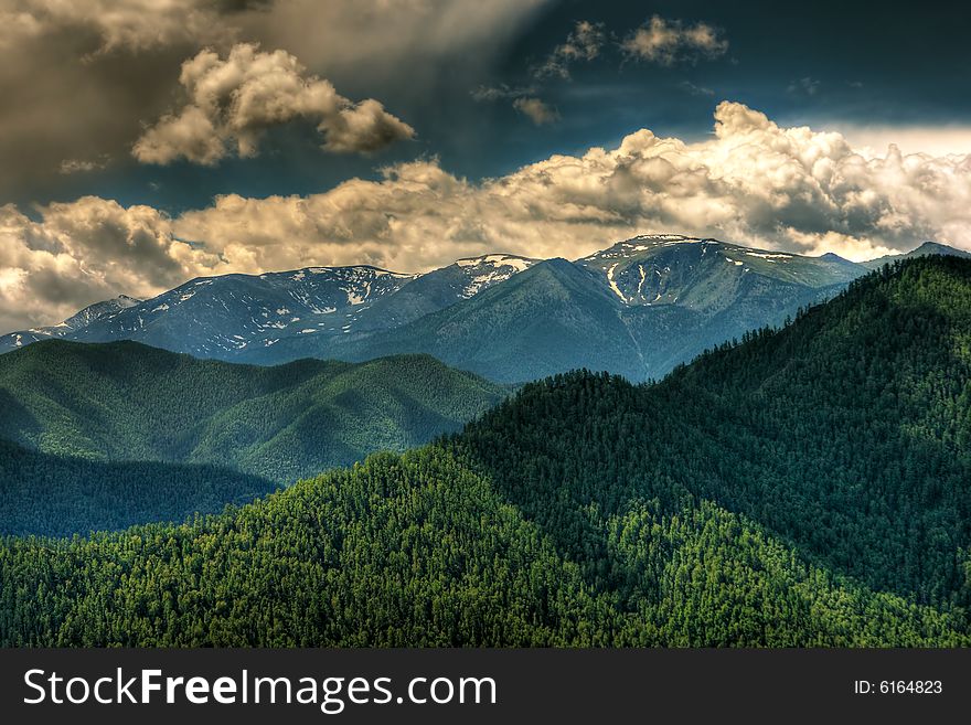 Remote glacier and clouds in mountains