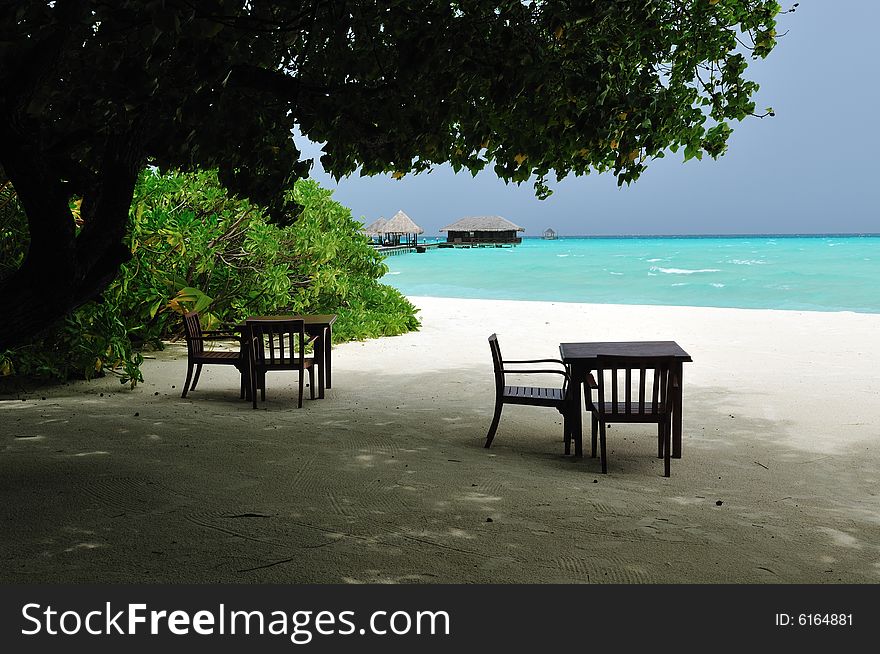 Couple of tables and chairs on a sandy beach in Maldives
