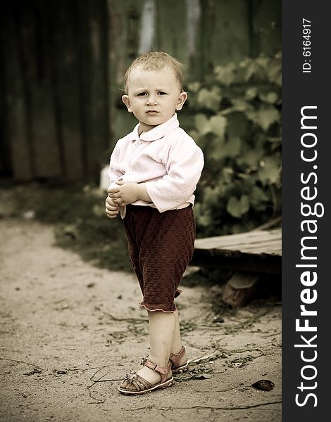 Portrait of a small girl on a background of fence. Portrait of a small girl on a background of fence