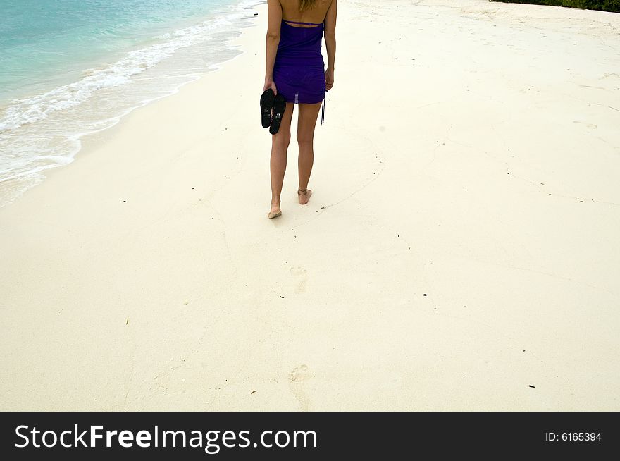 Woman walking on the sandy beach in Maldives