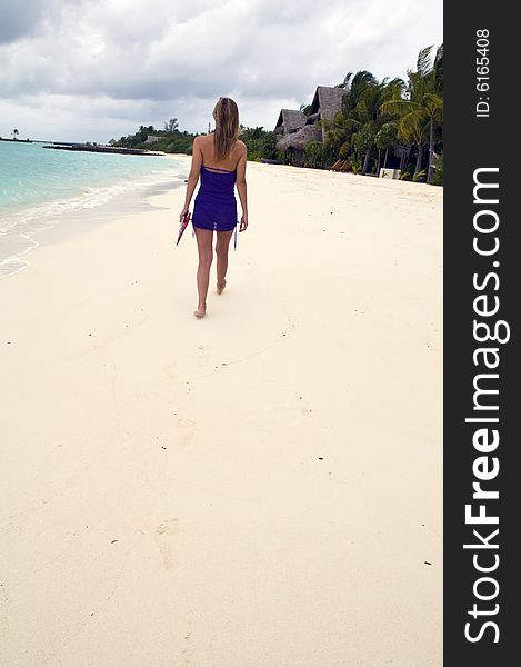 Woman Walking On The Sandy Beach