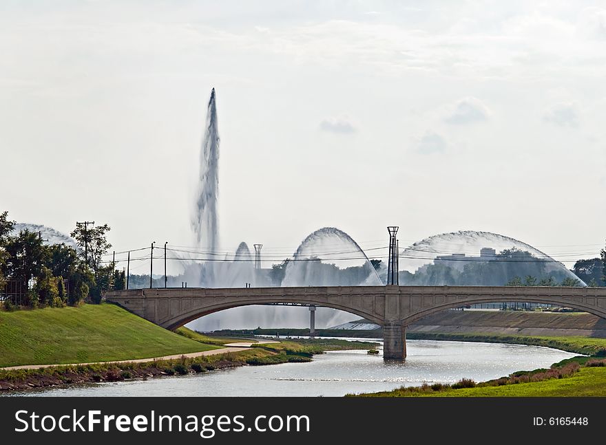 Fountains spaying by bridge over the river. Fountains spaying by bridge over the river.