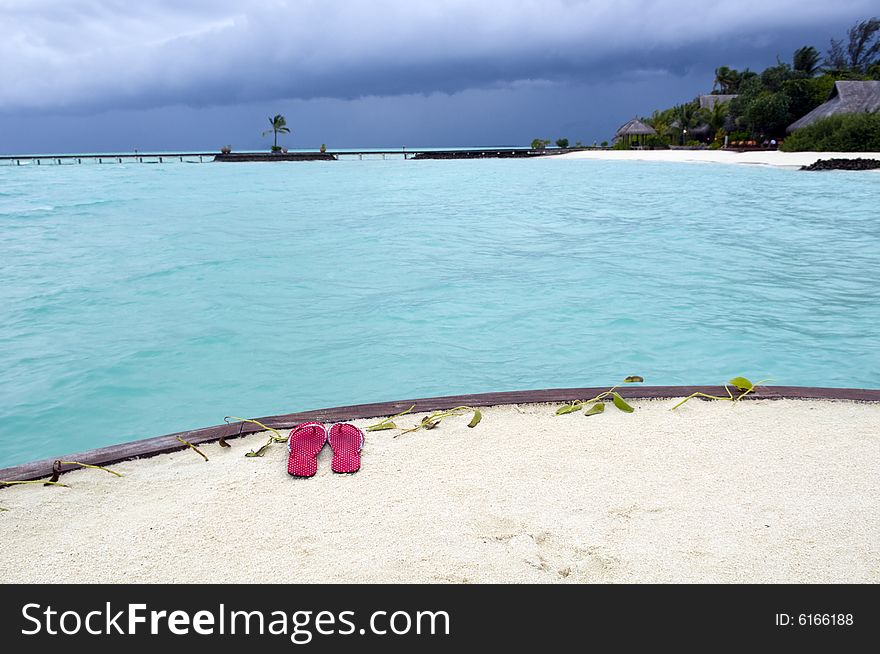 Red thongs on the sandy beach in Maldives