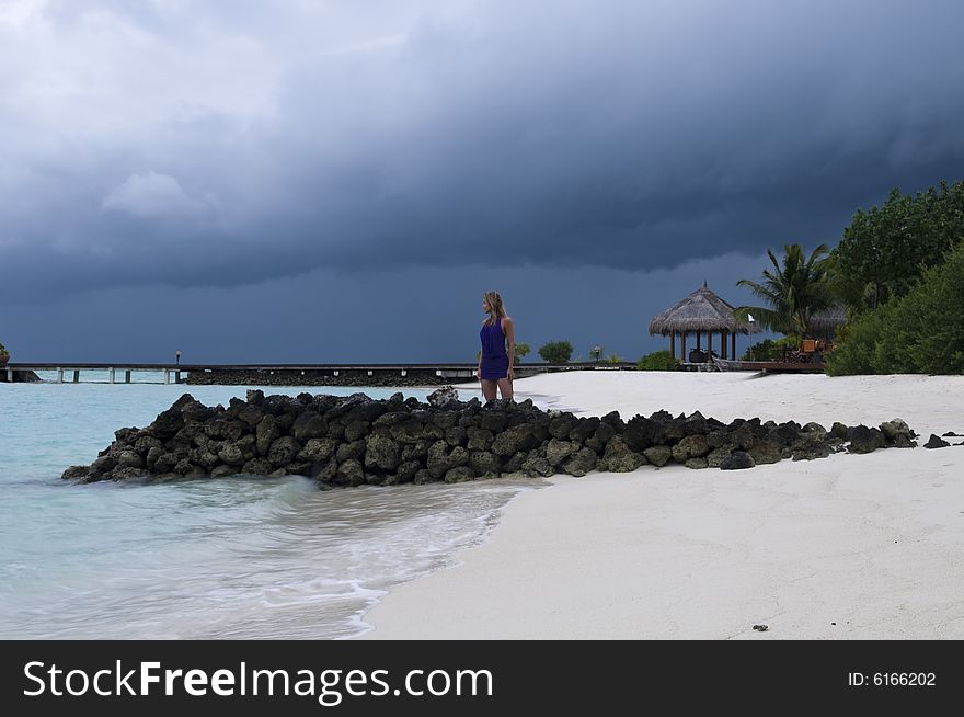 Sexy woman watching indian ocean in Maldives at sunset