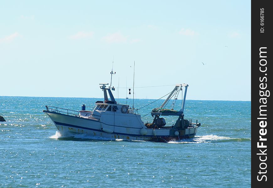 A good shot of a fishing boat that arrives in the port. A good shot of a fishing boat that arrives in the port