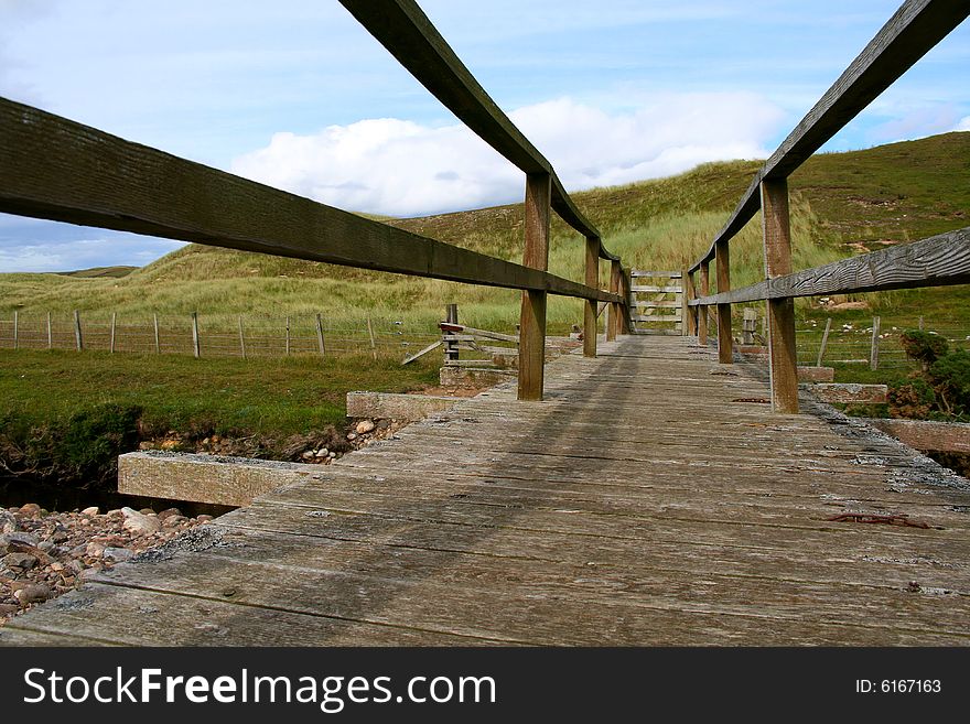 An old wooden footbridge gated at the end.