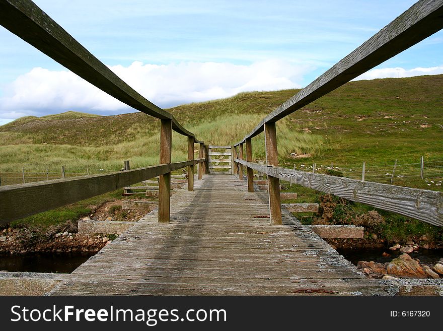 An old wooden footbridge gated at the end.